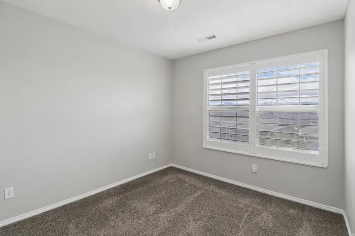 Empty room with dark carpet and baseboards