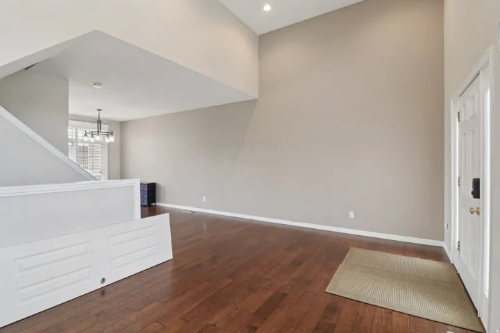 Foyer entrance featuring dark wood-style floors, a high ceiling, and hanging lights