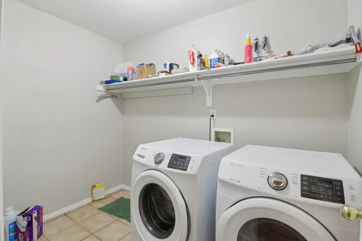Laundry room with washer and dryer and light tile patterned floors