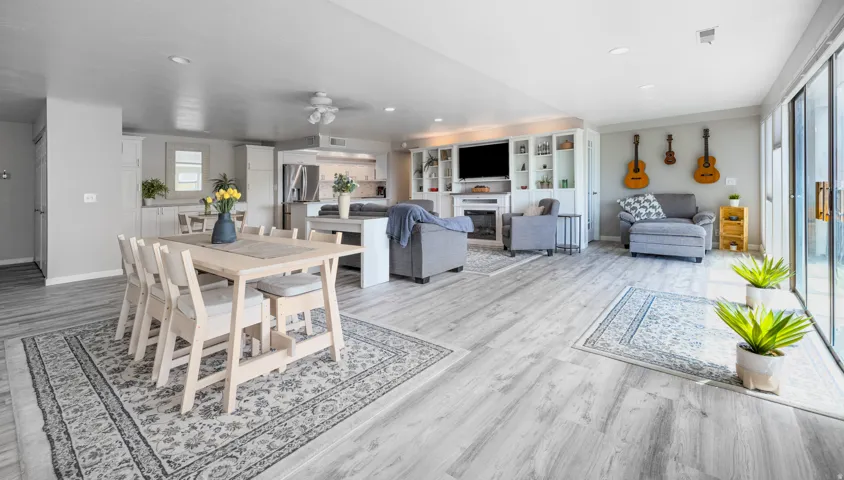 Dining room featuring a ceiling fan, light wood-type flooring, a glass covered fireplace, and recessed lighting