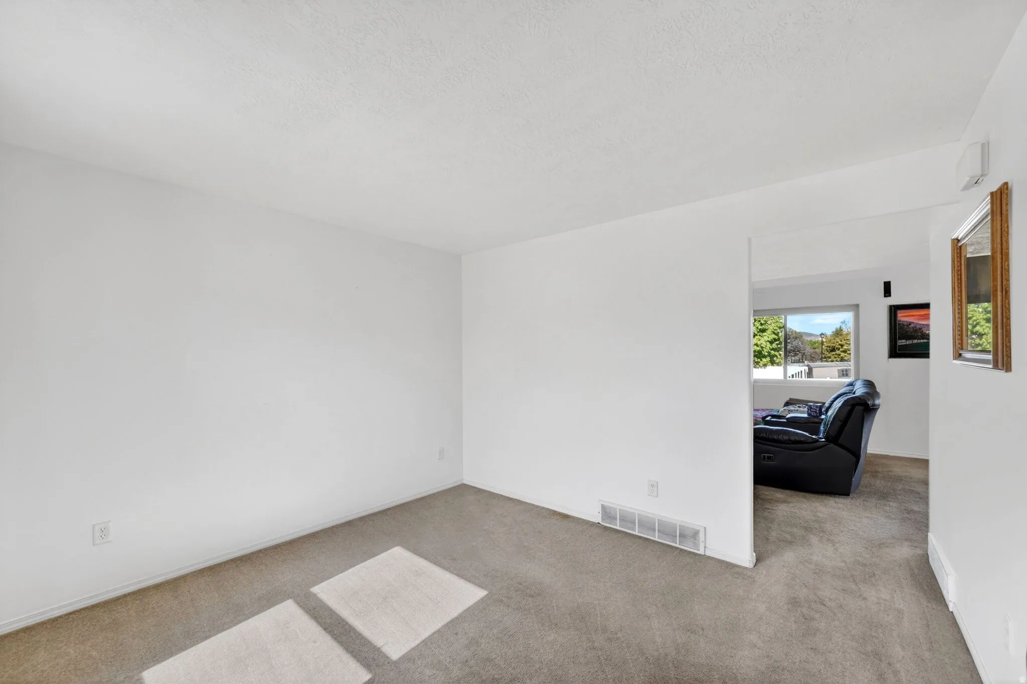 Spare room with light colored carpet and a textured ceiling
