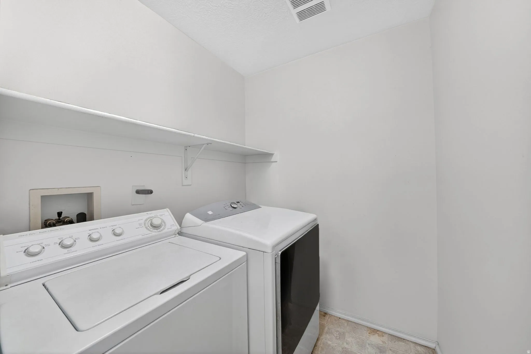 Laundry room featuring washing machine and clothes dryer and baseboards