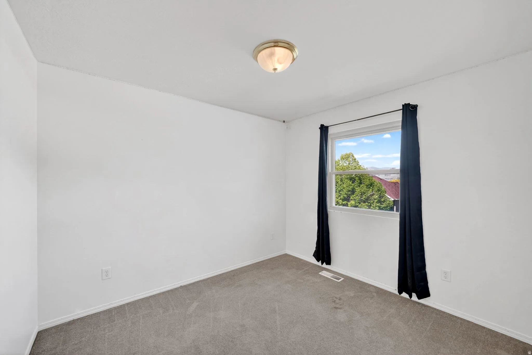 Spare room with carpet and baseboards