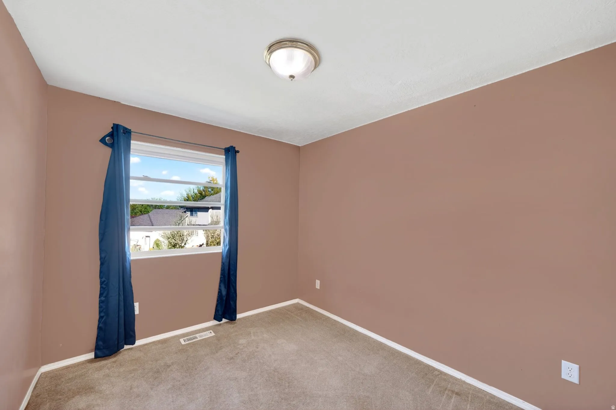 Spare room featuring light colored carpet and baseboards