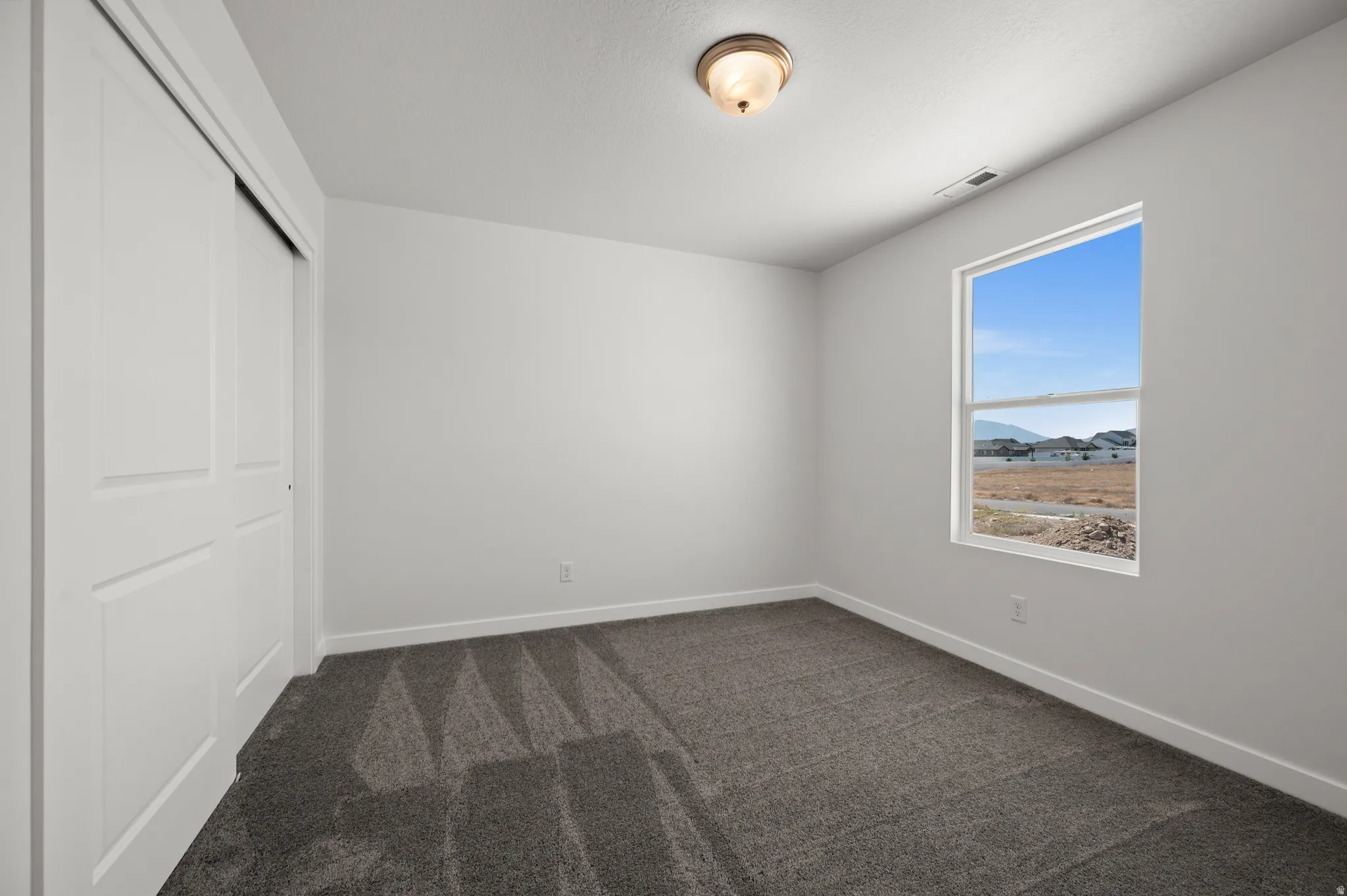 Unfurnished bedroom with a closet and dark colored carpet