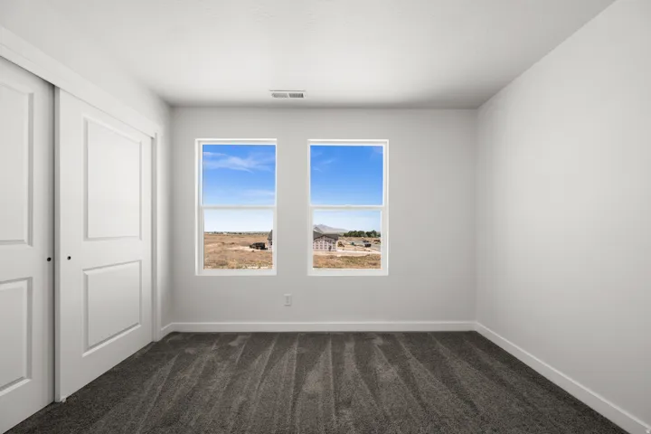 Unfurnished bedroom with dark carpet and a closet