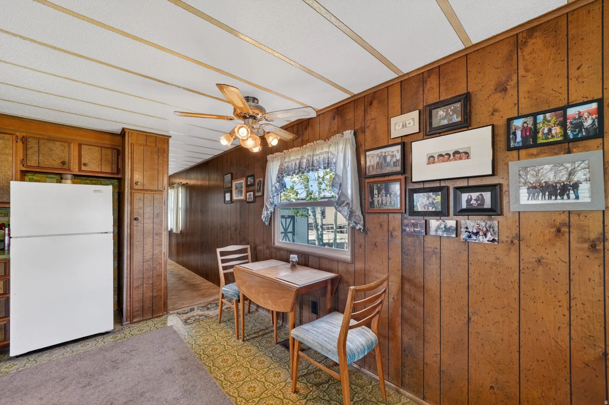Dining room with wood walls and a ceiling fan