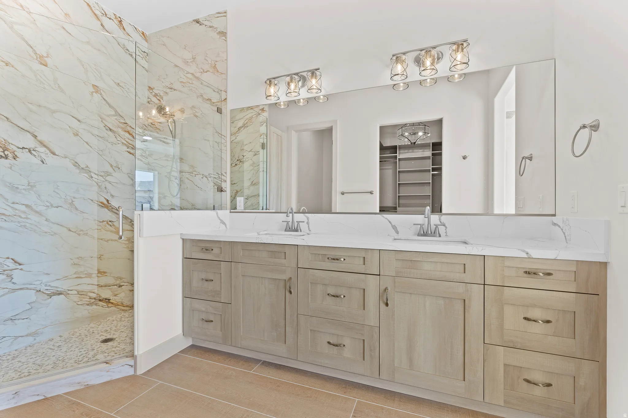Bathroom with double vanity, a marble finish shower, and a spacious closet