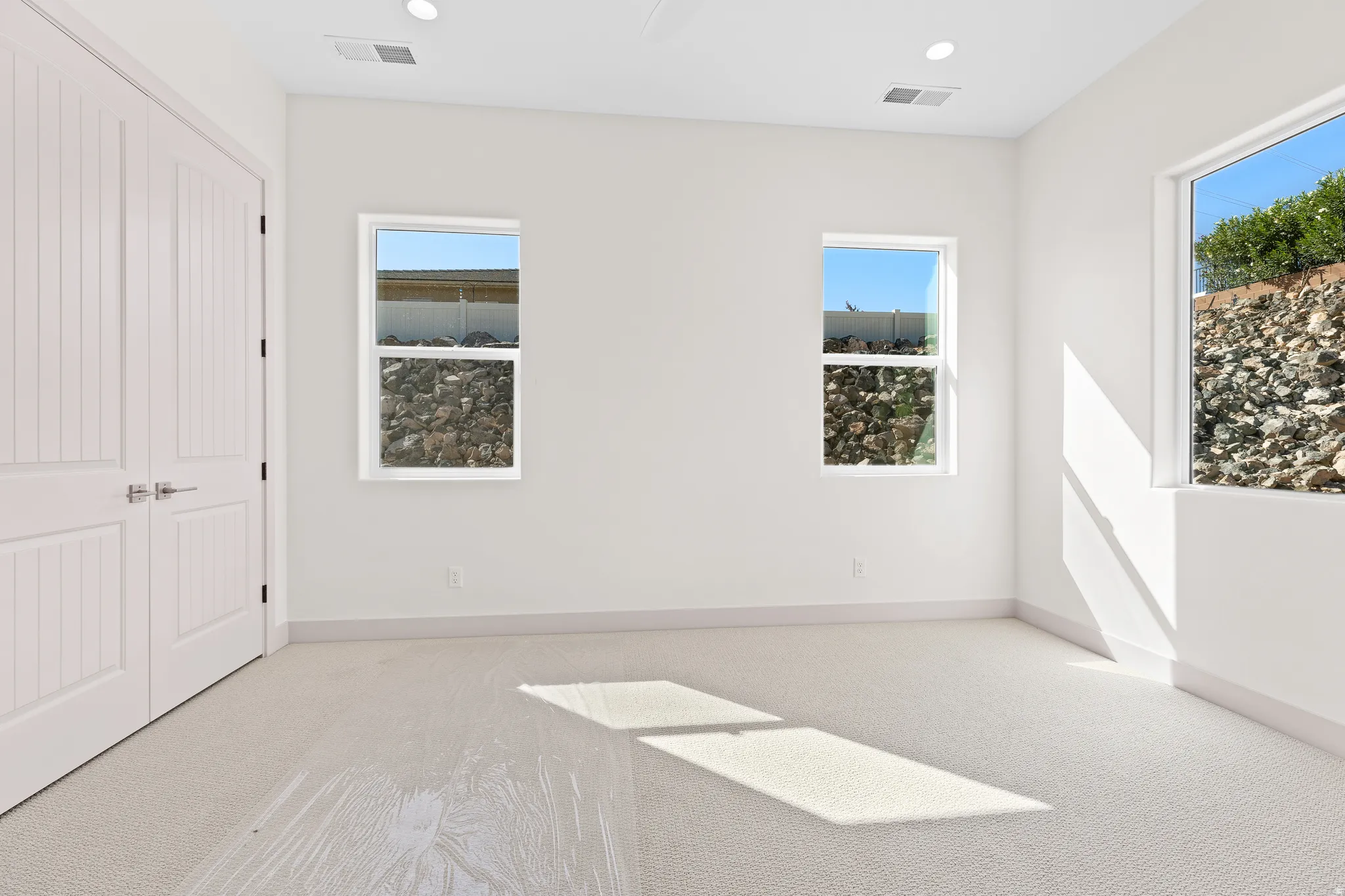 Unfurnished bedroom featuring light colored carpet, a closet, and recessed lighting