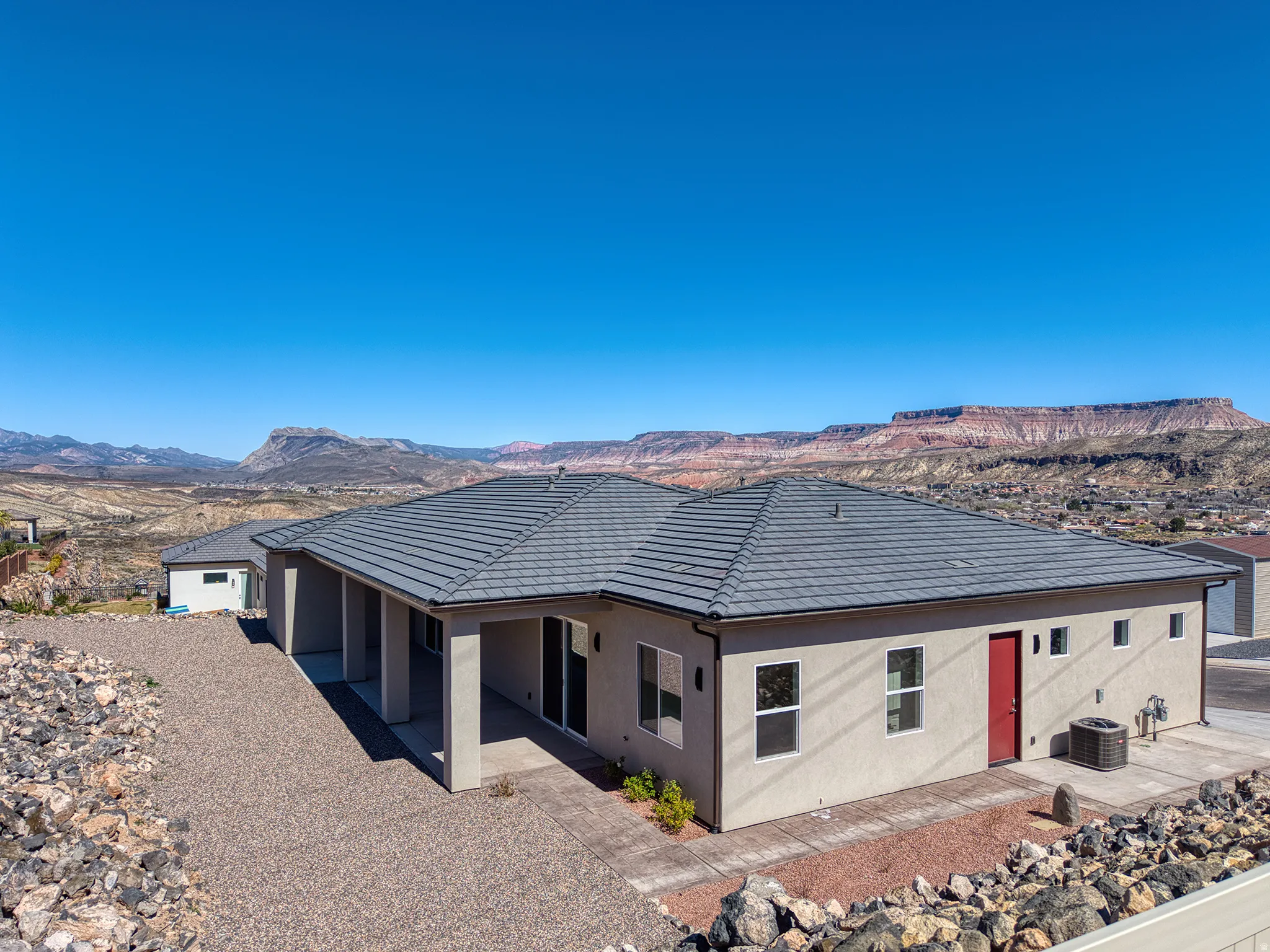 Back of house featuring a mountain view, stucco siding, and a patio area