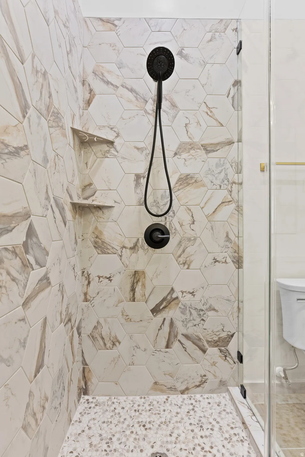 Bathroom with a shower stall and toilet