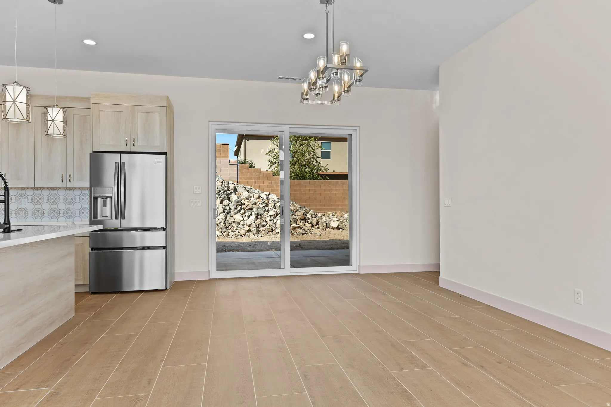 Unfurnished dining area featuring suspended lighting and light wood-style floors