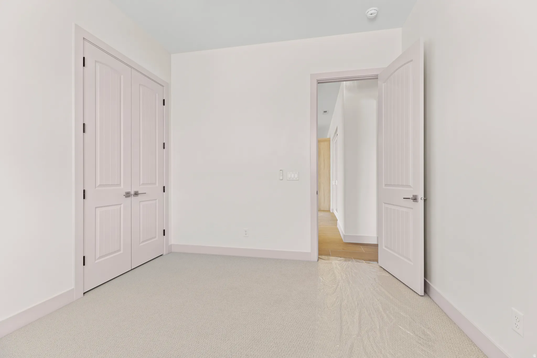 Unfurnished bedroom with light colored carpet and a closet