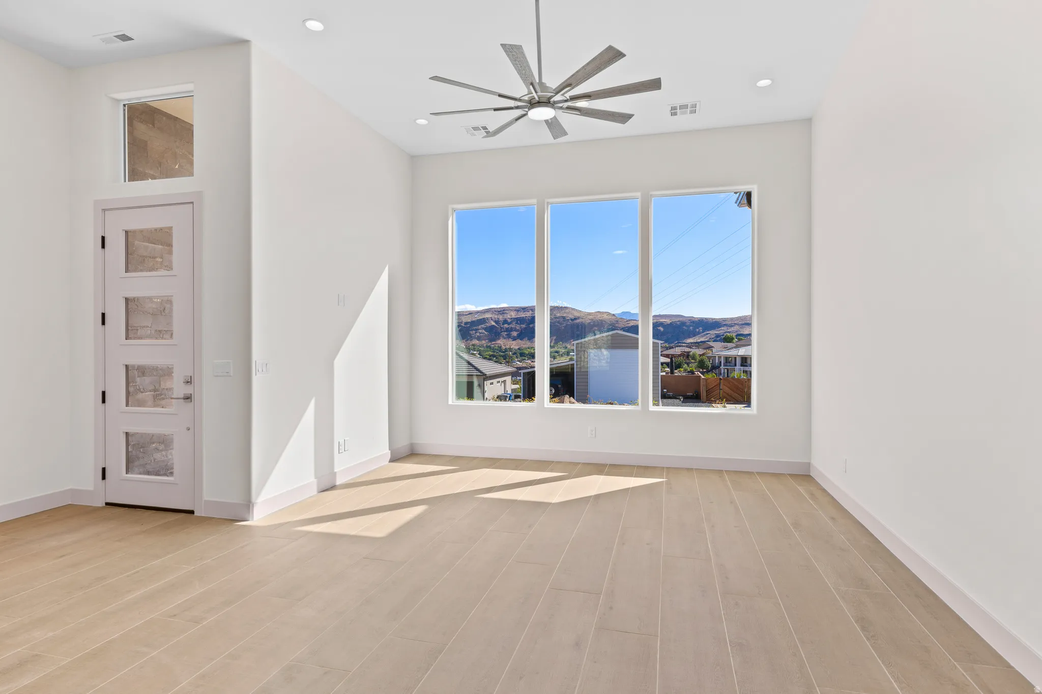 Spare room featuring a mountain view, a ceiling fan, light wood finished floors, and recessed lighting