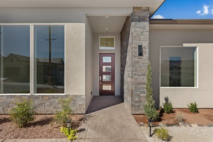 Property entrance with stone siding and stucco siding
