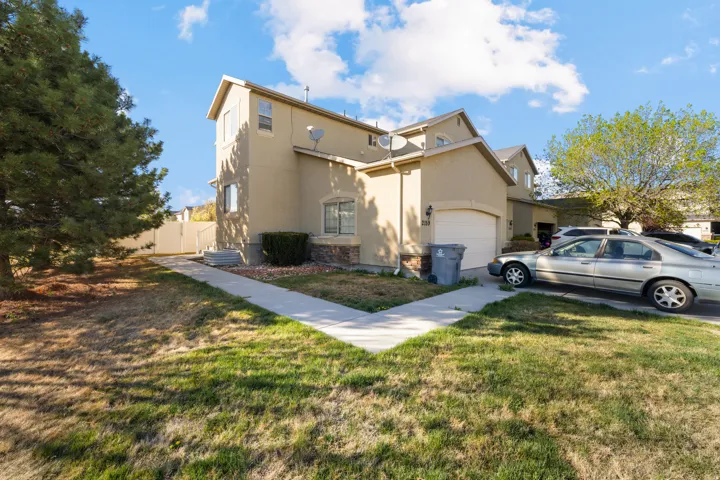 View of front facade with stucco siding and an attached garage