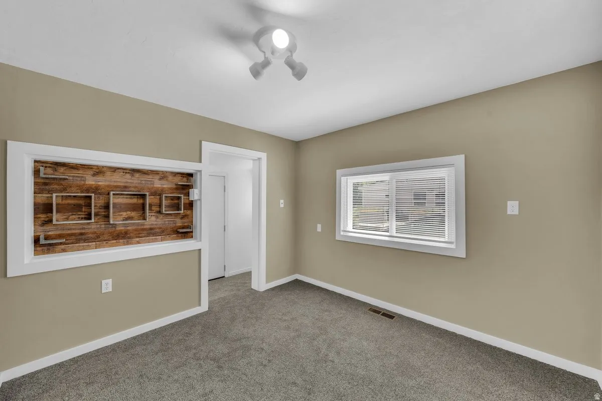 Room featuring an accent wall with wood paneling and integrated display shelving