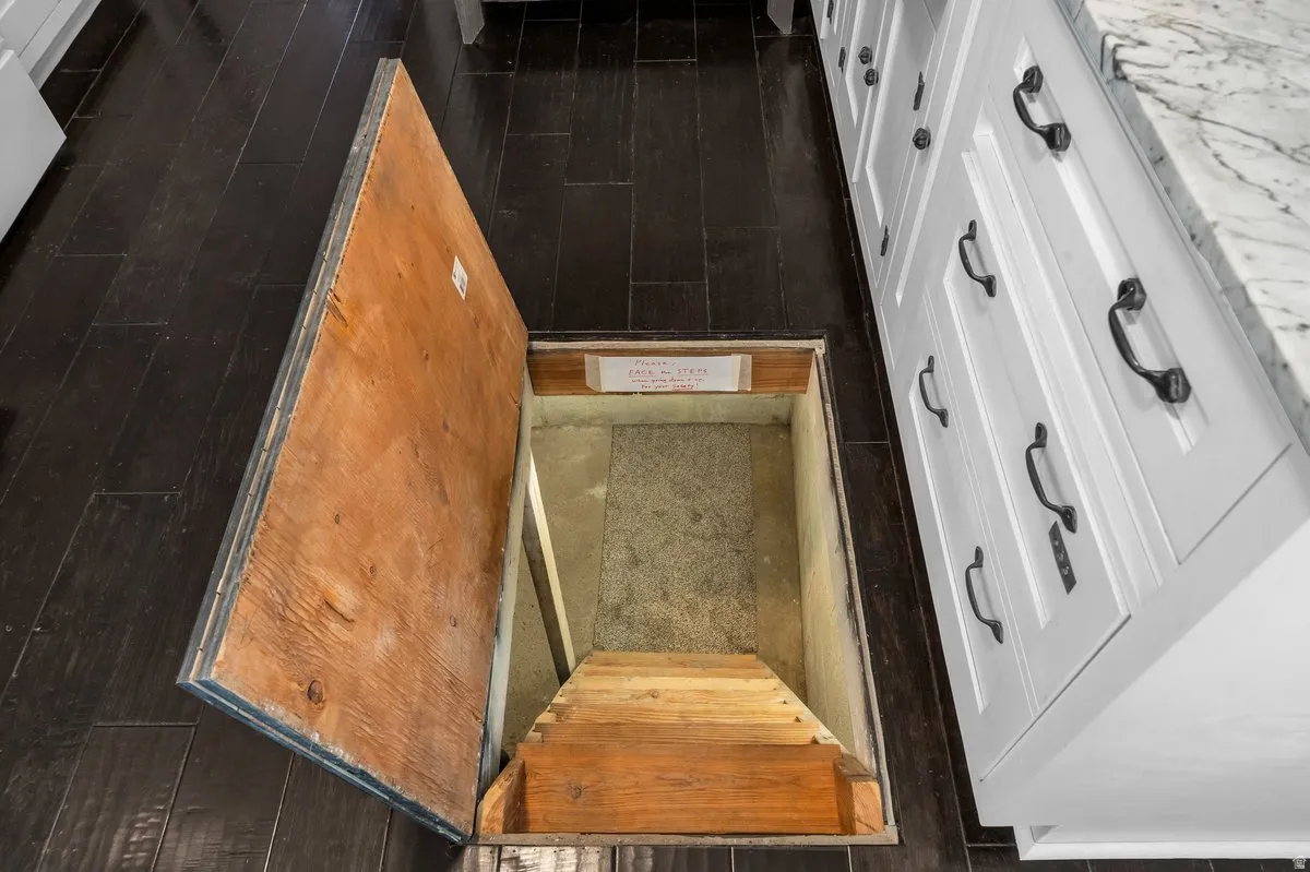 Wood-finish flooring with a subfloor access hatch, featuring a wood stairwell