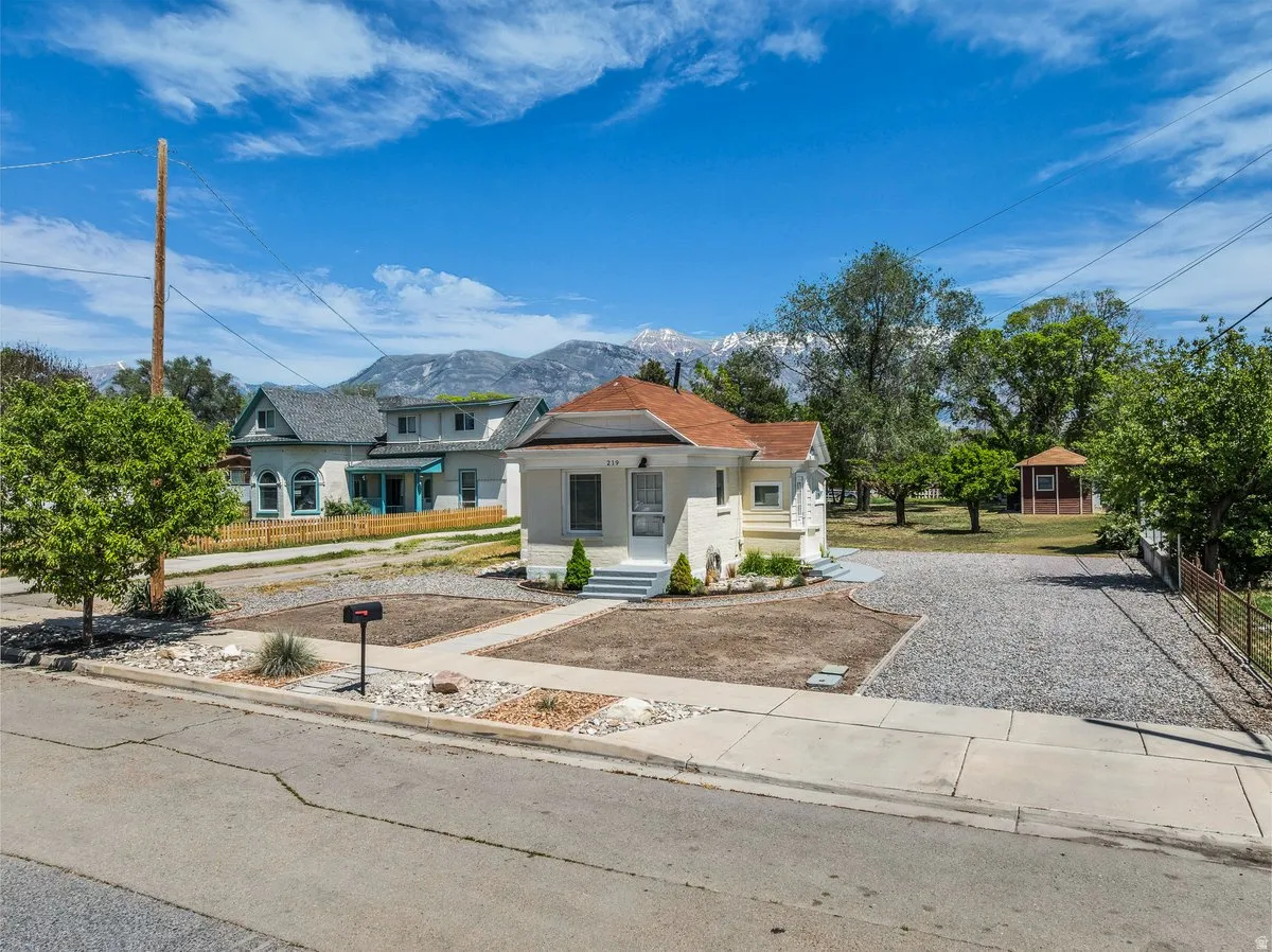 Single-story residence featuring a front entry porch, gravel driveway, and a partially landscaped front yard