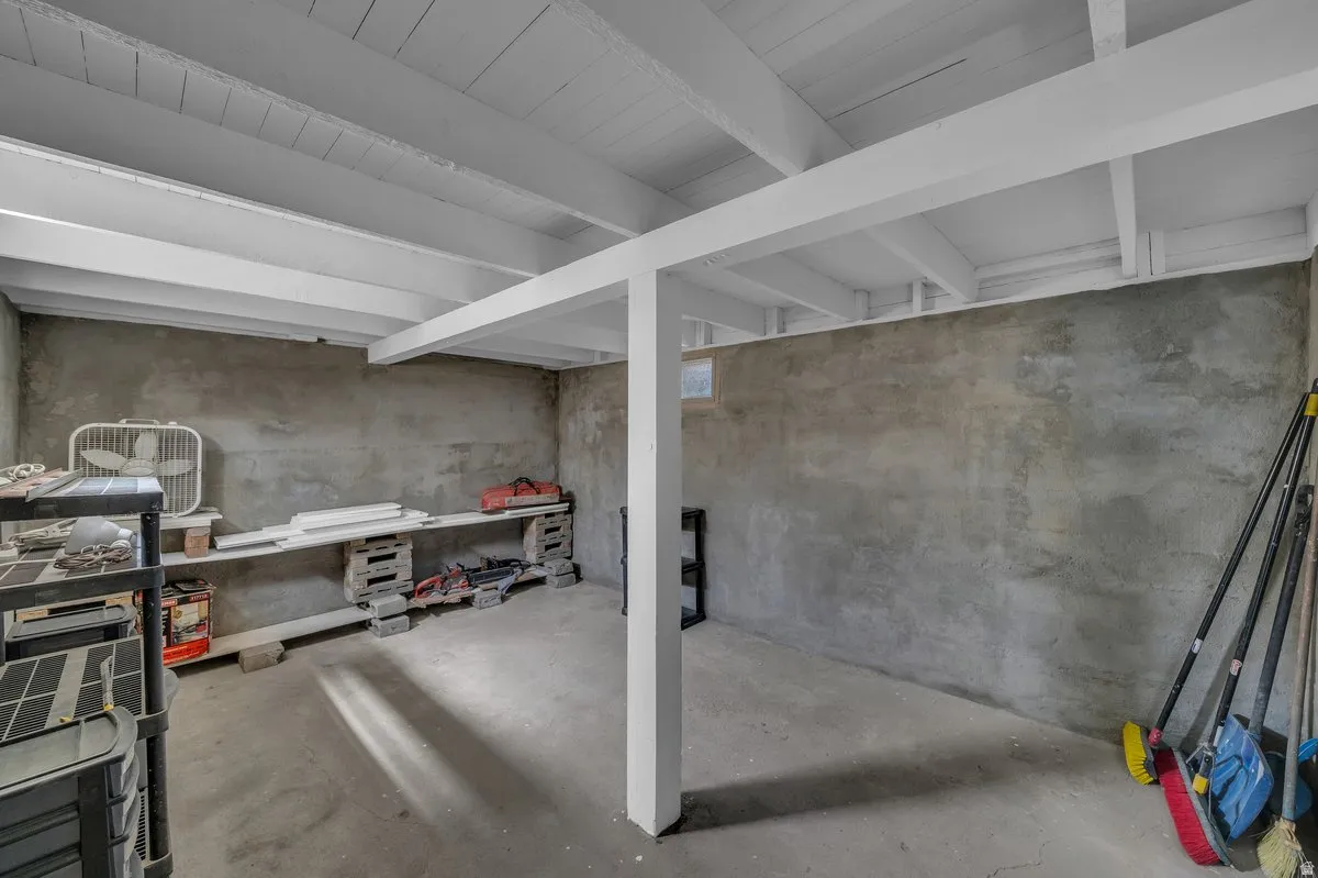 Unfinished basement space featuring exposed concrete walls and flooring