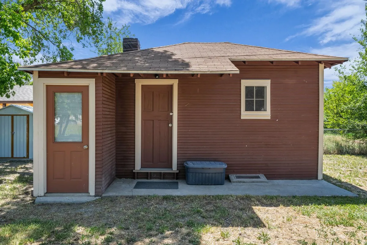 Red horizontal siding exterior with a shingled roof and concrete patio