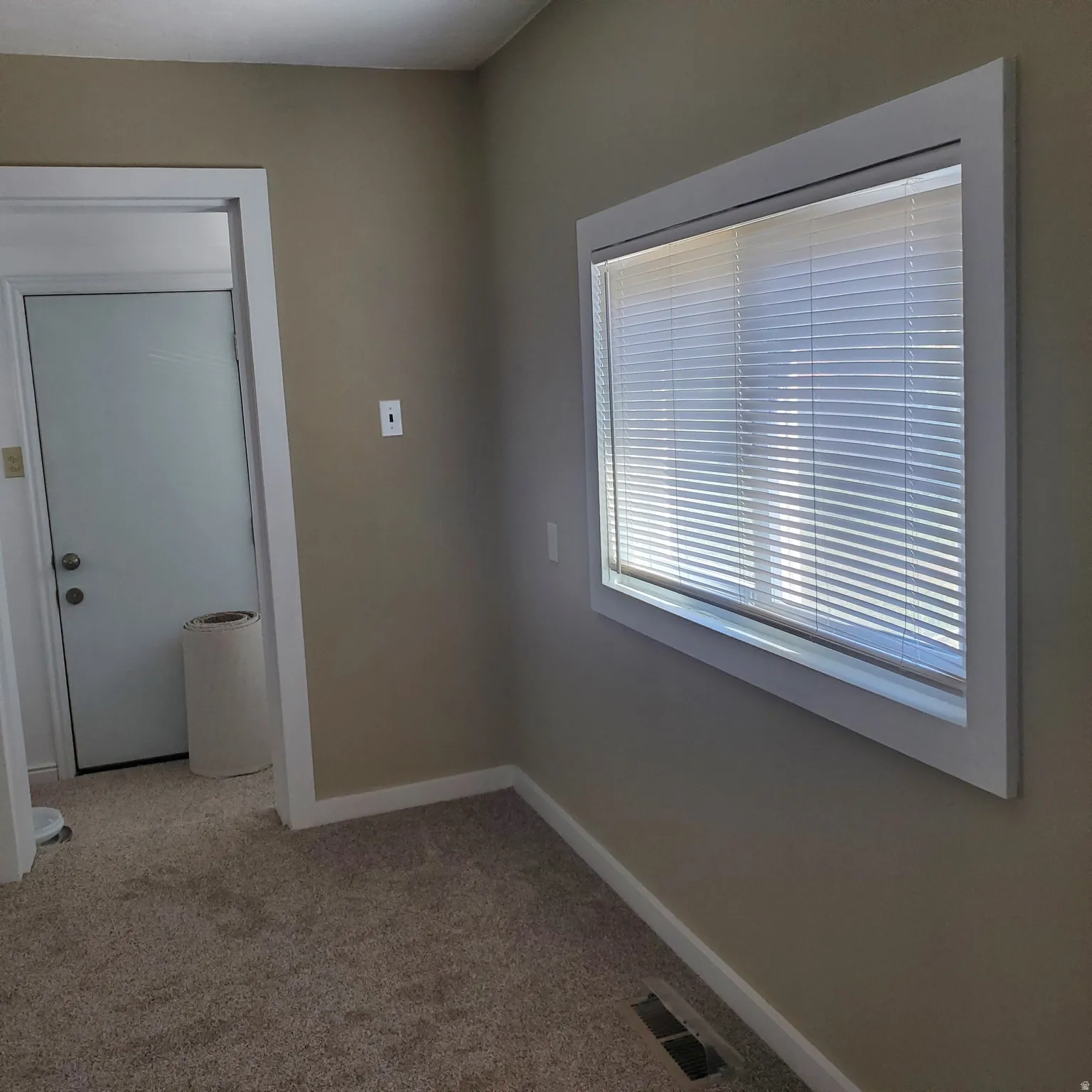 Spare room featuring light carpet and baseboards