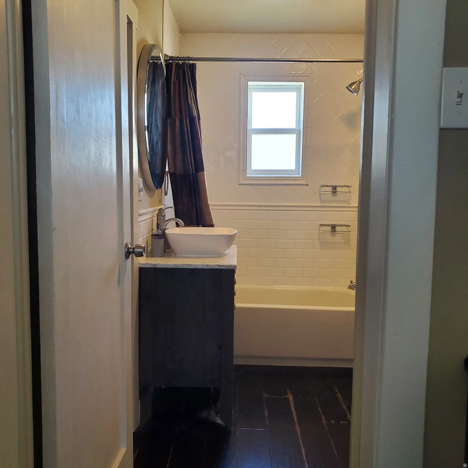 Full bathroom featuring vanity, dark wood-type flooring, and shower / bath combination with curtain