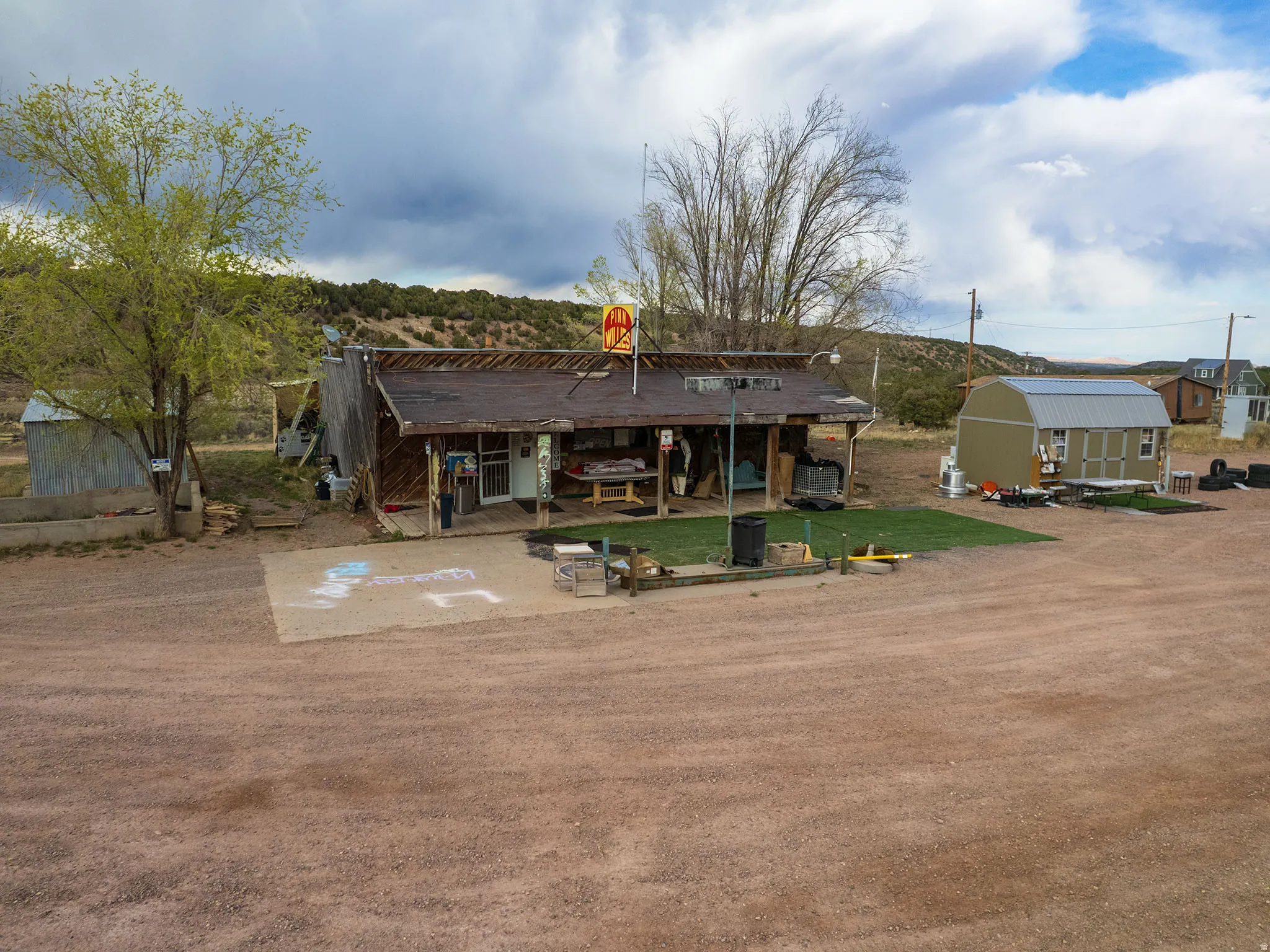Rustic building with a covered front porch and a prominent commercial sign