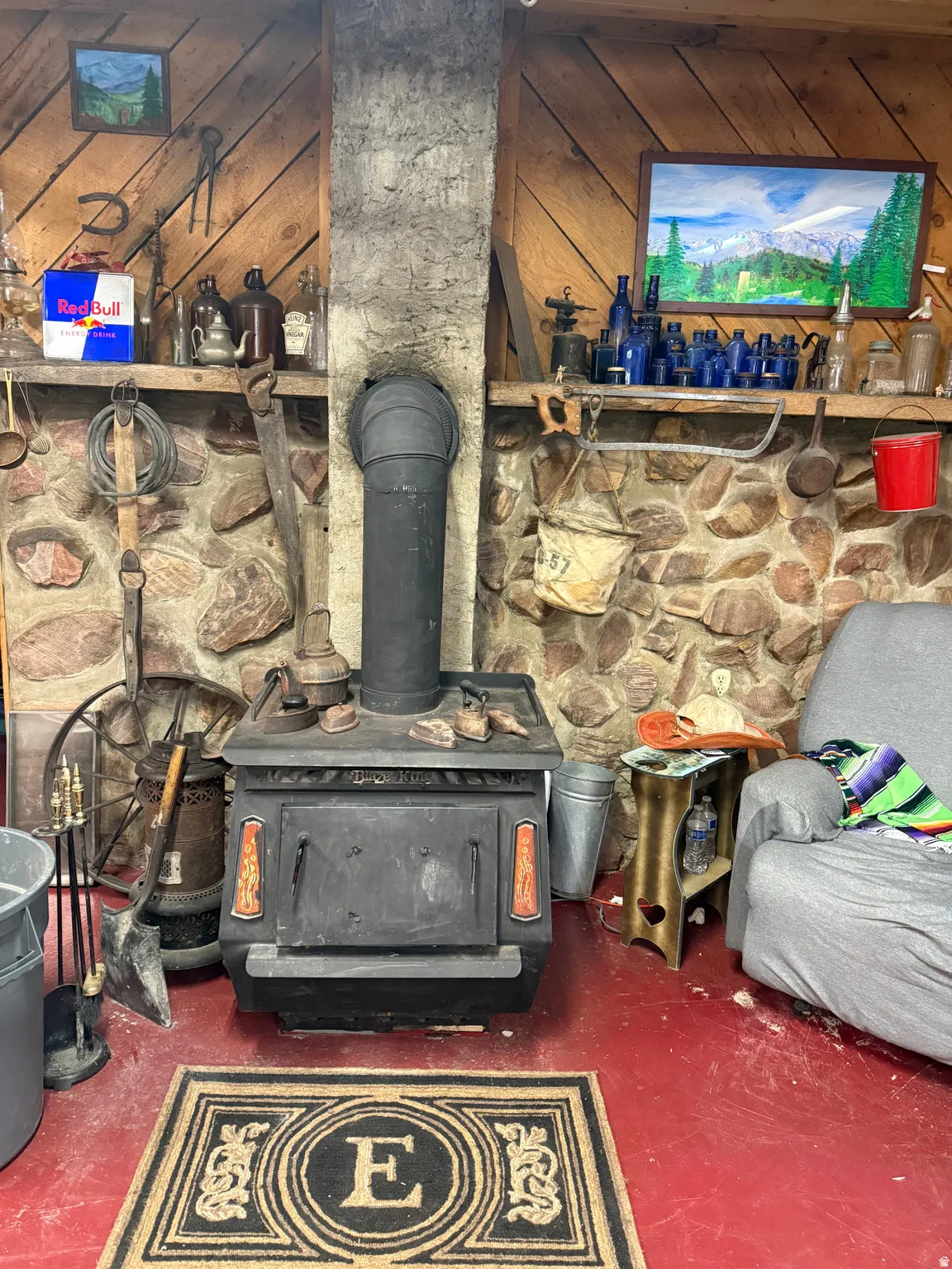 Stone accent wall with a built-in wood-burning stove featuring a black finish