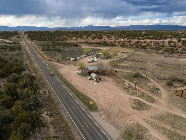 Rural property featuring a long paved road frontage, natural landscaping, and distant mountain ranges