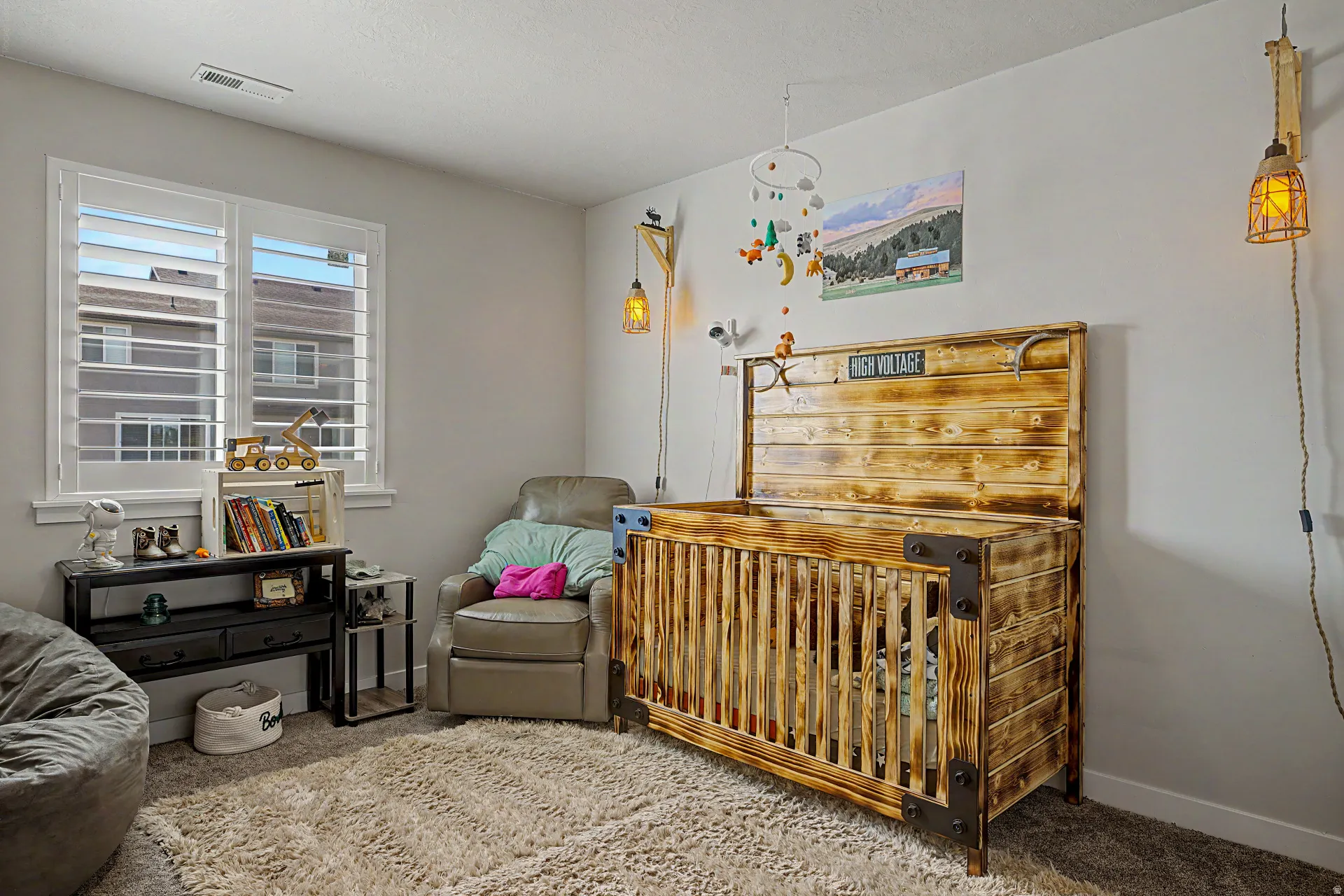Carpeted bedroom featuring a crib and baseboards