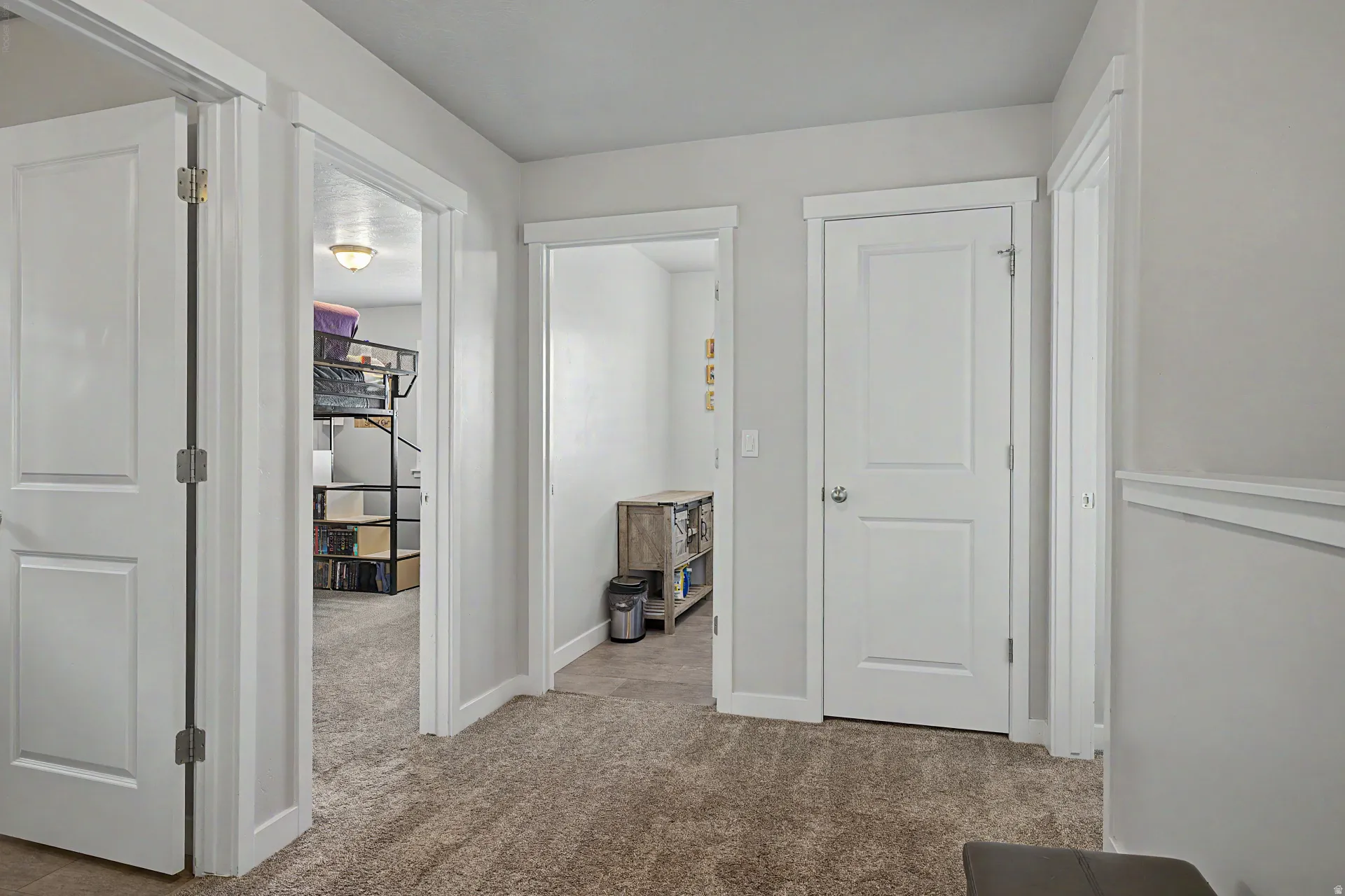 Hall featuring light carpet and baseboards