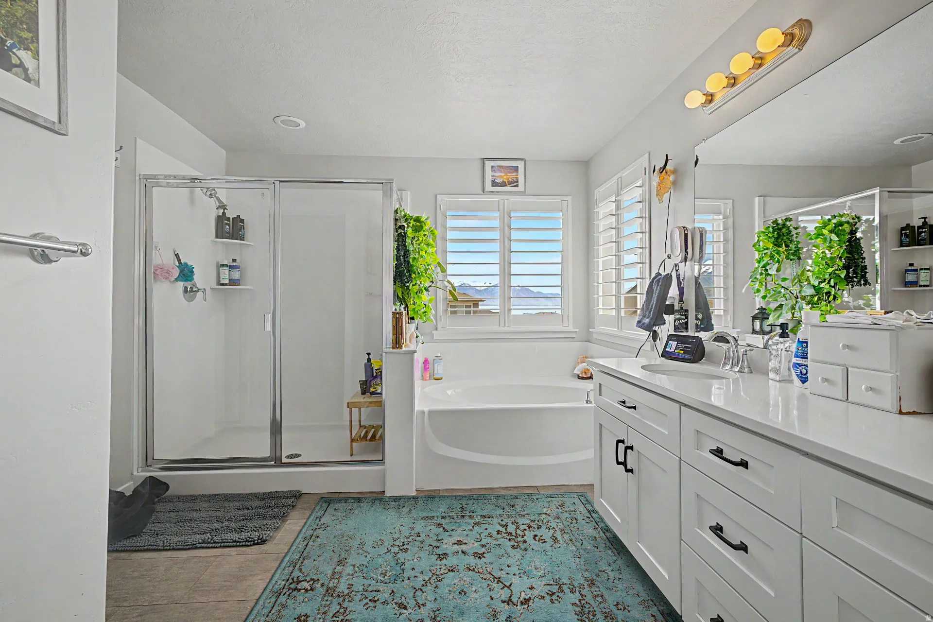 Bathroom featuring vanity, a stall shower, a bath, and light tile patterned floors