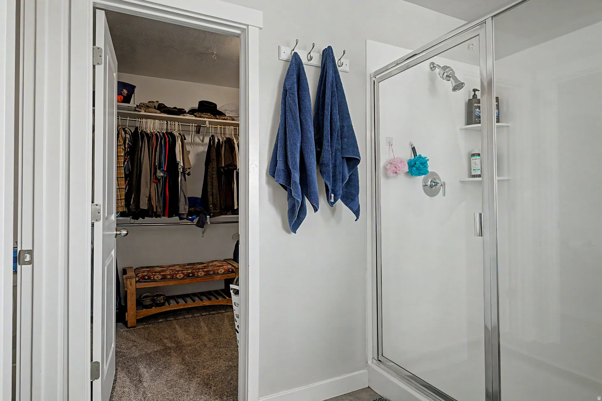 Full bath with a walk in closet, a shower stall, and dark carpet