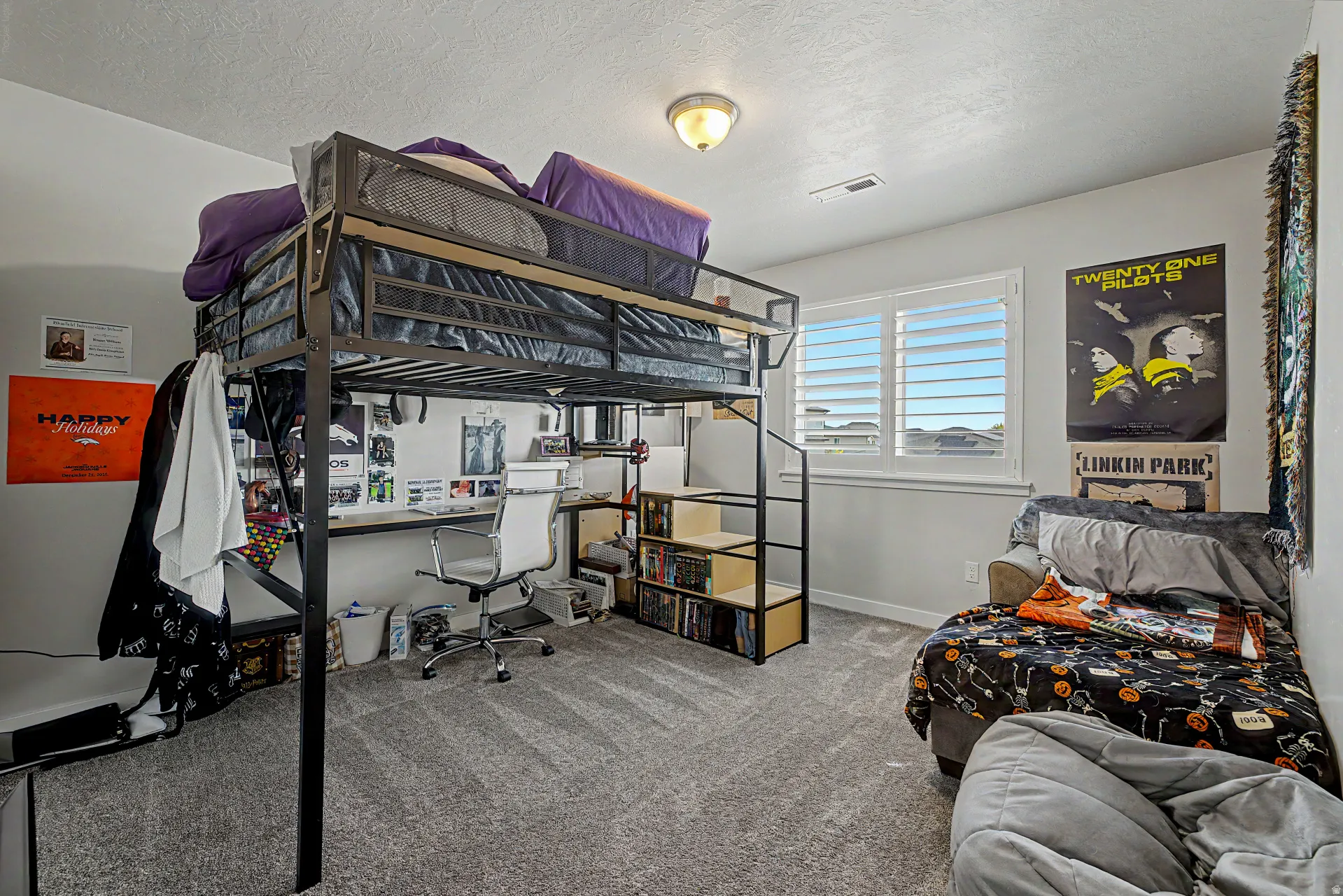 Bedroom featuring light carpet, a desk, and a textured ceiling