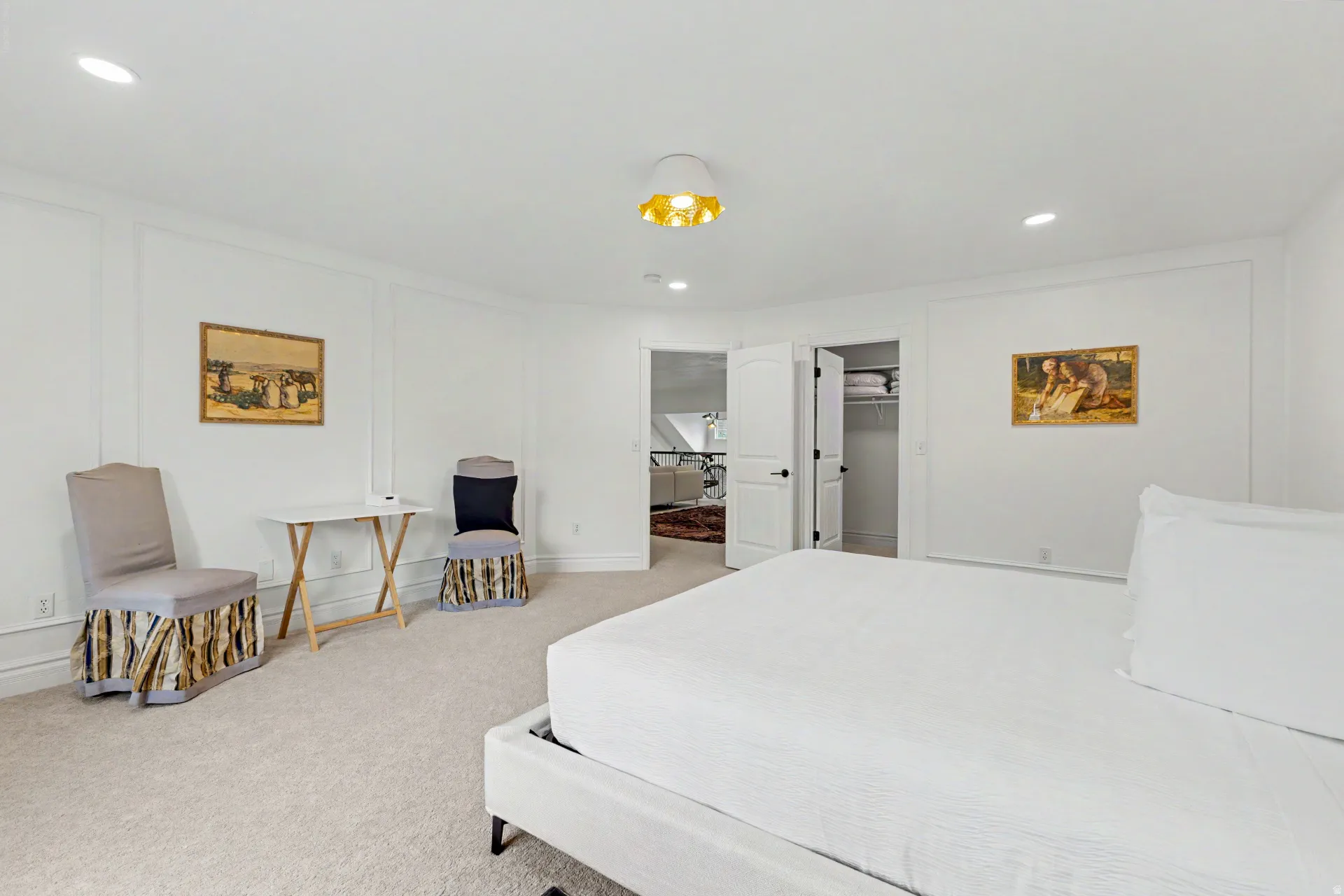 Bedroom with a decorative wall, recessed lighting, a walk in closet, and light carpet