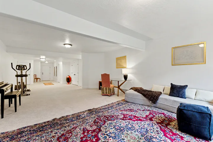 Living room with light carpet, beam ceiling, and a textured ceiling