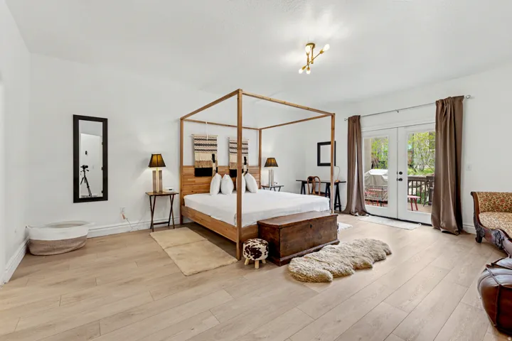 Bedroom with french doors, access to exterior, and light wood-type flooring