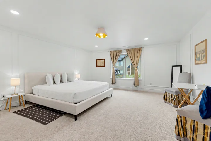 Bedroom featuring a decorative wall, light colored carpet, and recessed lighting