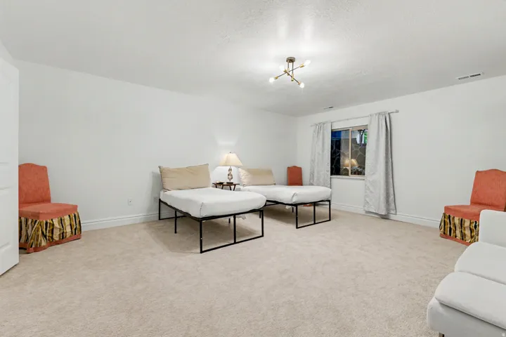 Living area with light colored carpet and a textured ceiling