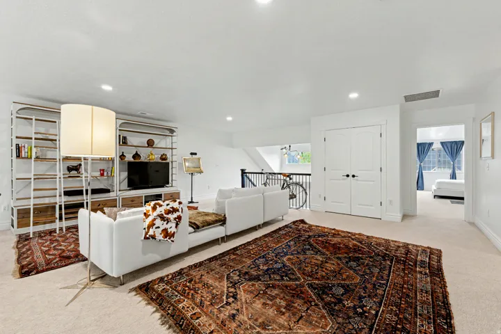 Living area with light colored carpet and recessed lighting