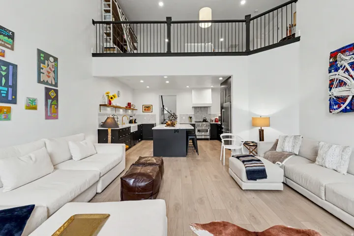 Living room with light wood-style flooring, recessed lighting, and a high ceiling