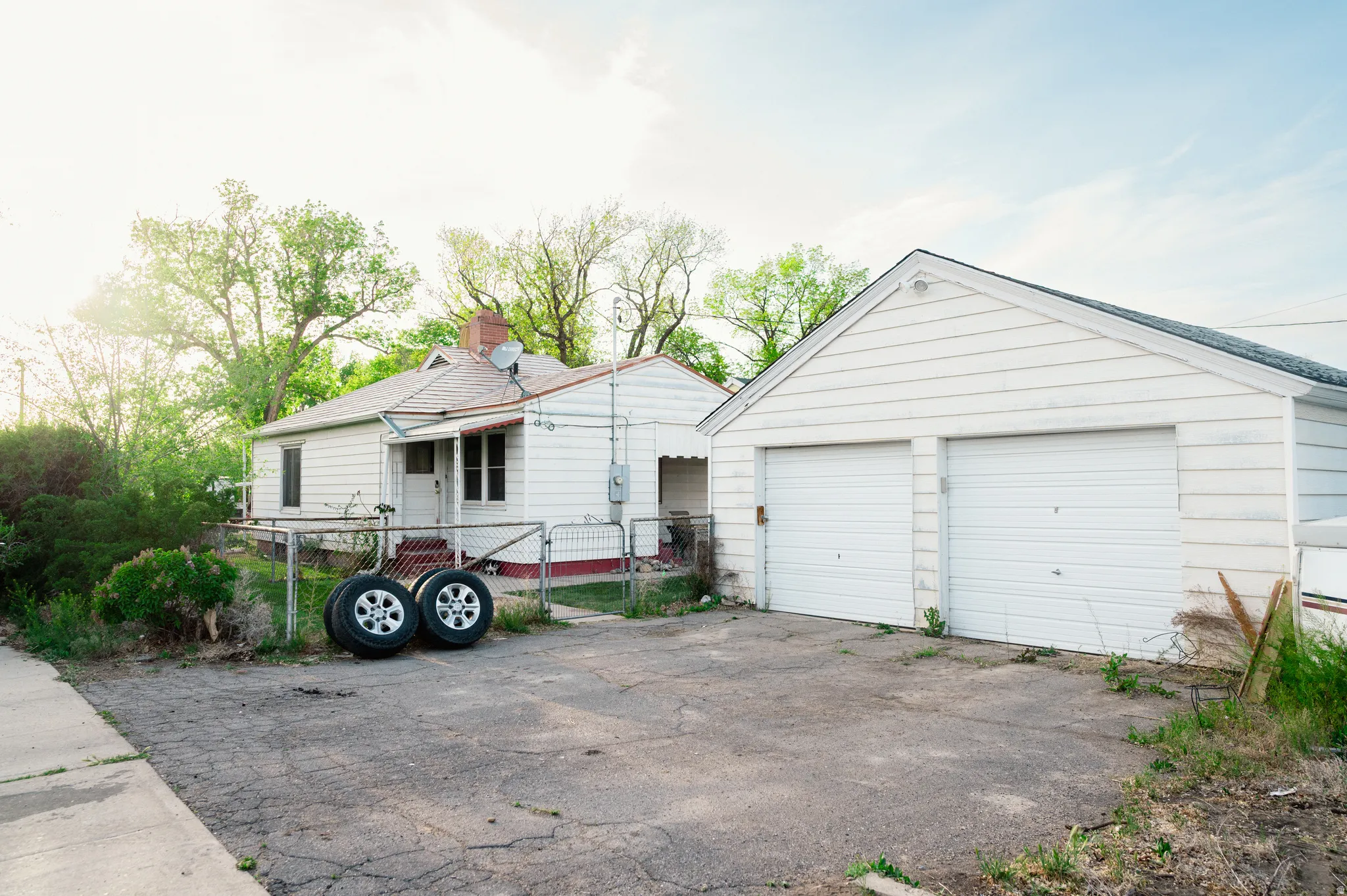 View of front of property with an outbuilding, a chimney, and a detached garage