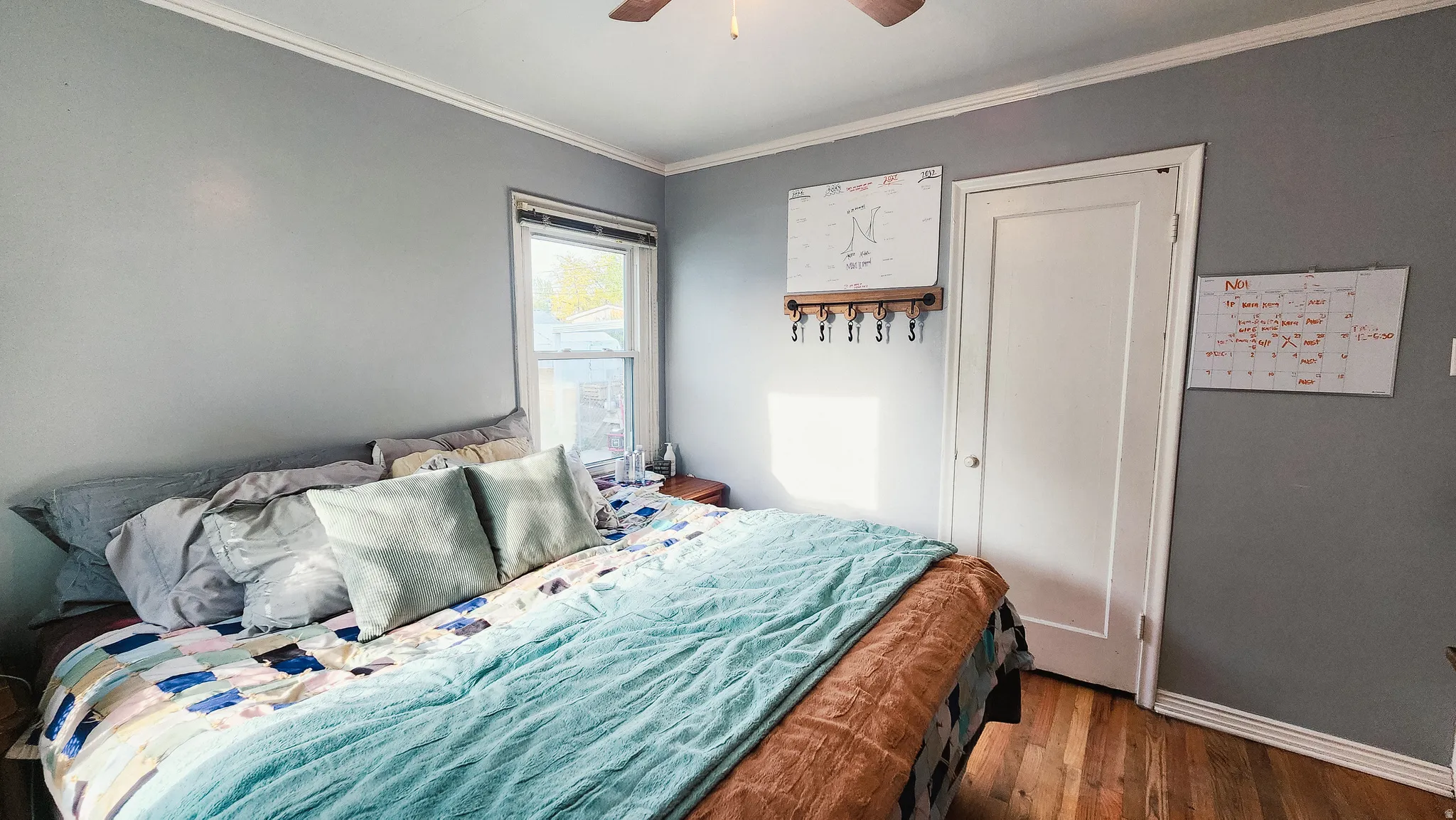 Bedroom featuring ornamental molding, wood finished floors, and ceiling fan
