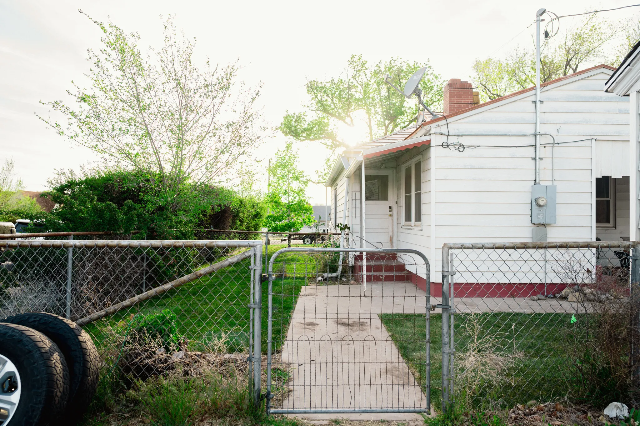 View of property exterior featuring a gate, a fenced front yard, and a chimney