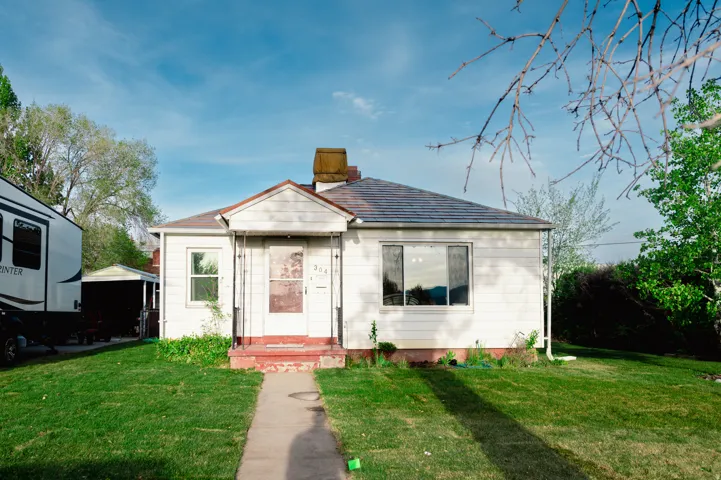 Bungalow-style house featuring a front lawn and a chimney