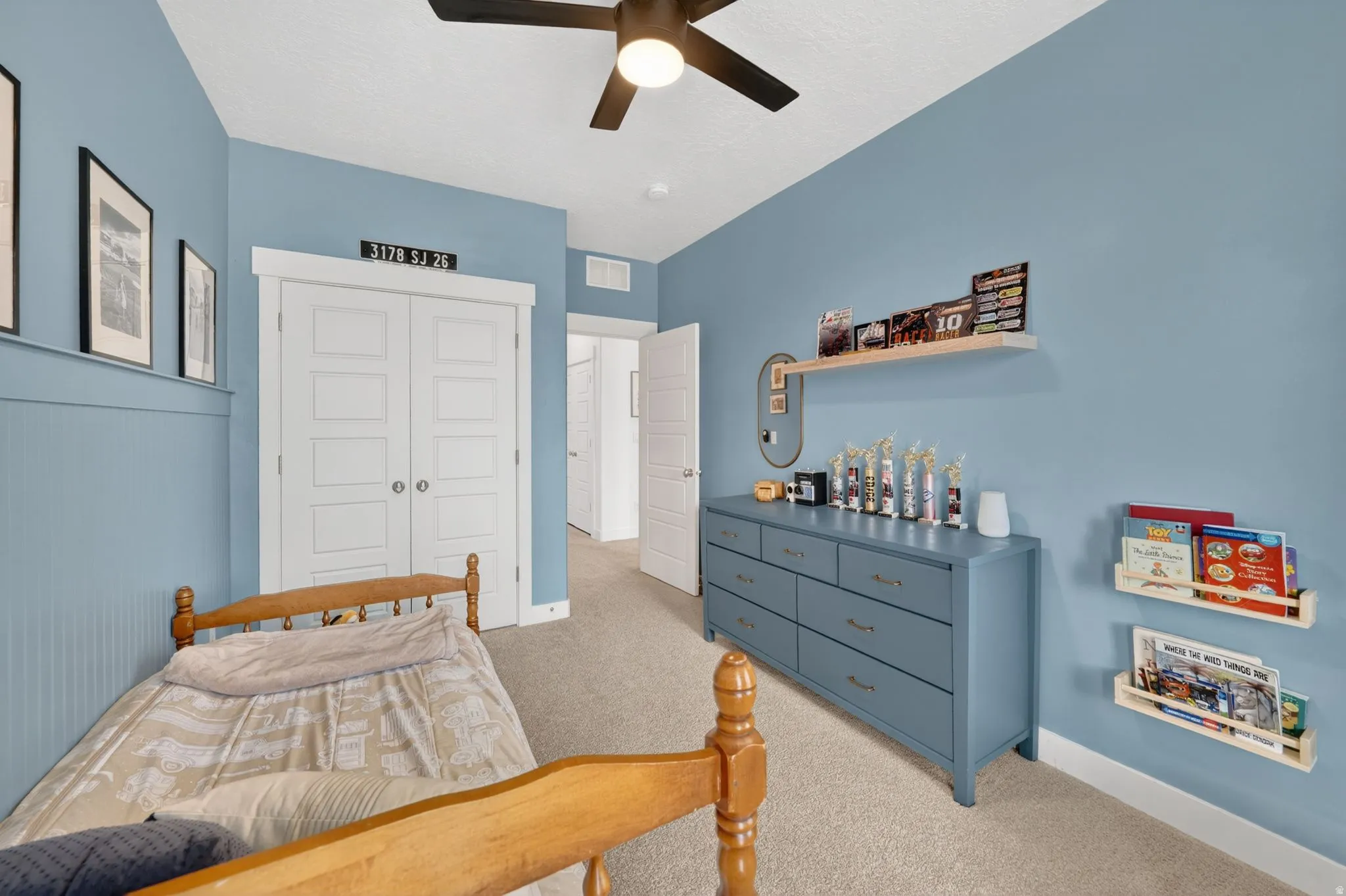 Bedroom with a closet, light carpet, and a ceiling fan