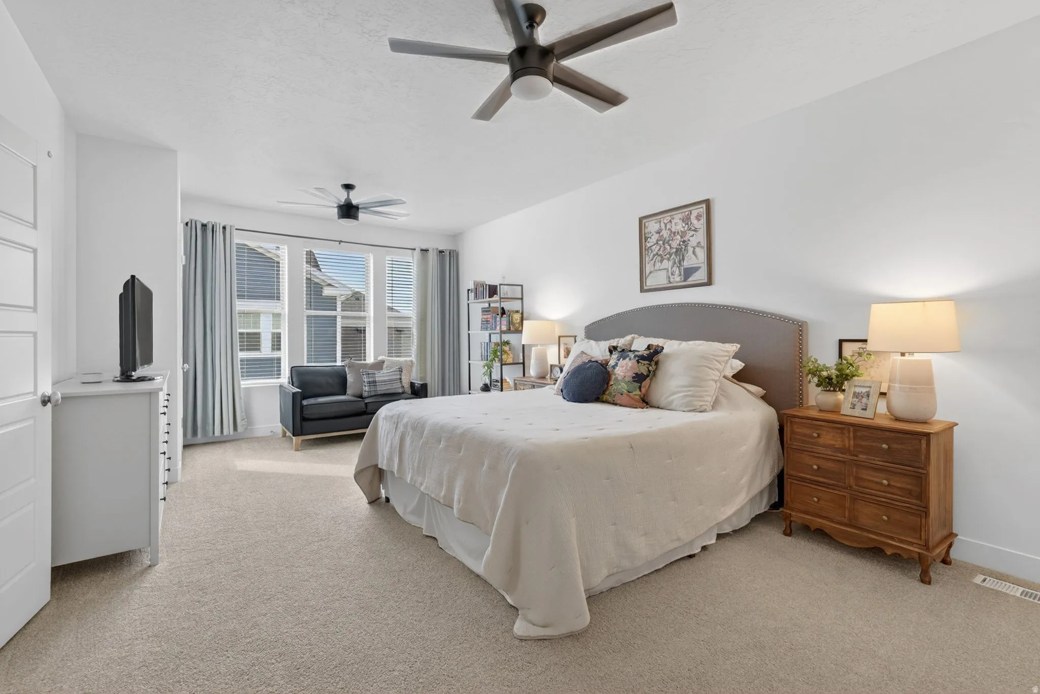 Bedroom featuring light colored carpet and a ceiling fan