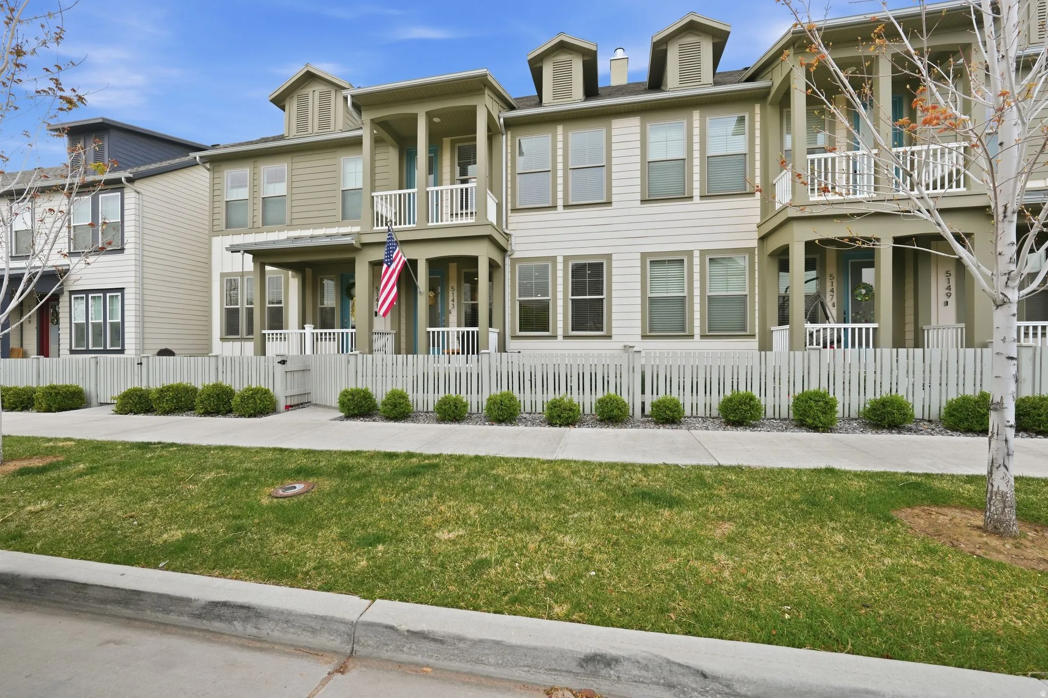 View of front of house featuring a fenced front yard, a gate, and a balcony