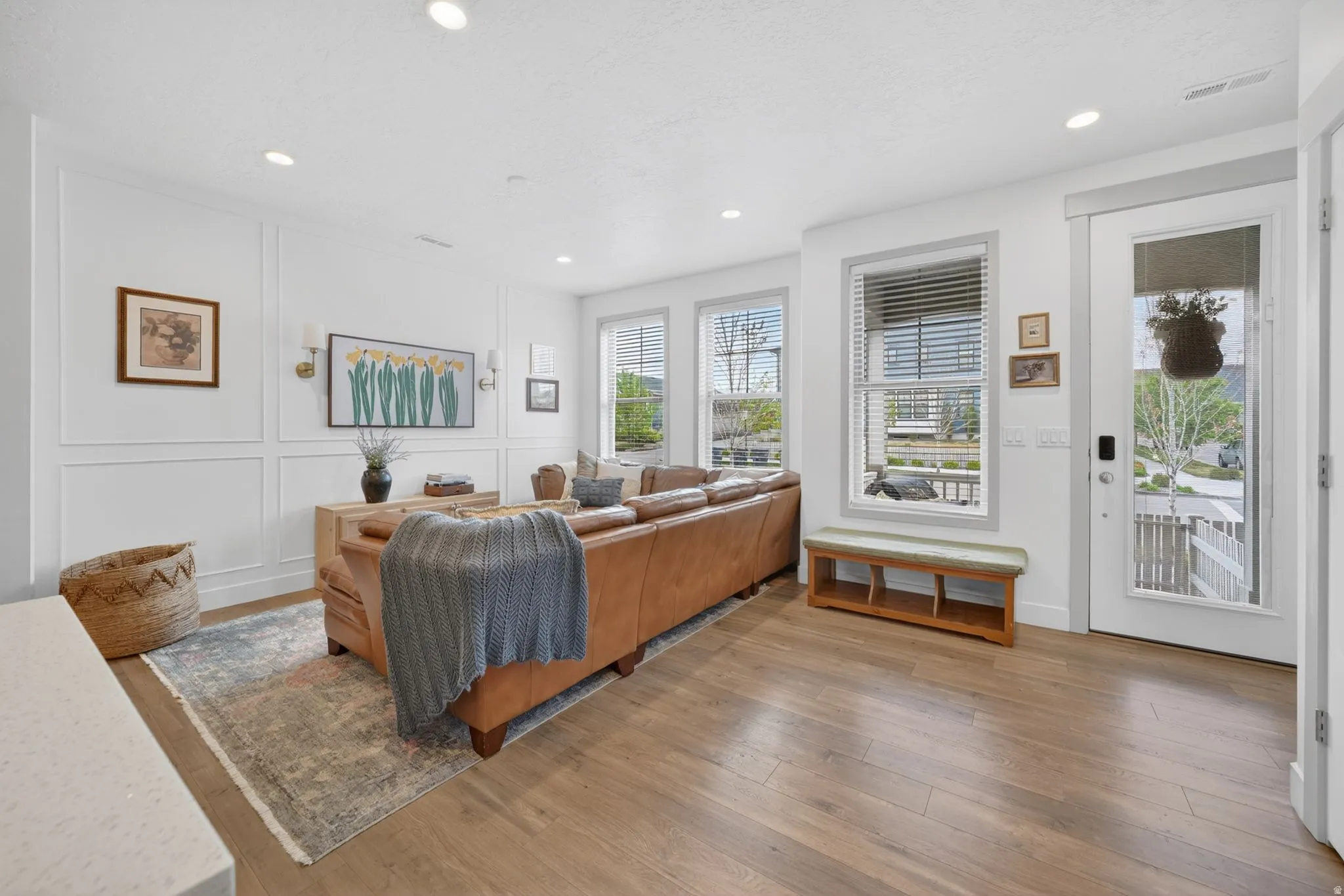 Living room with a decorative wall, hardwood / wood-style floors, and recessed lighting